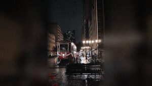 Rua das Flores deserta à noite com reflexos na calçada úmida